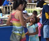 Seven-year-old Hana Stewart gets a helping hand with cotton candy from mom Hirimi.